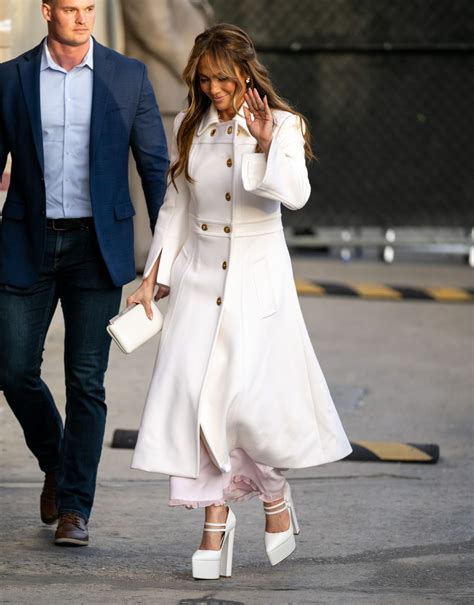 Jennifer Lopez in Dior con cappotto bianco e stivali di 